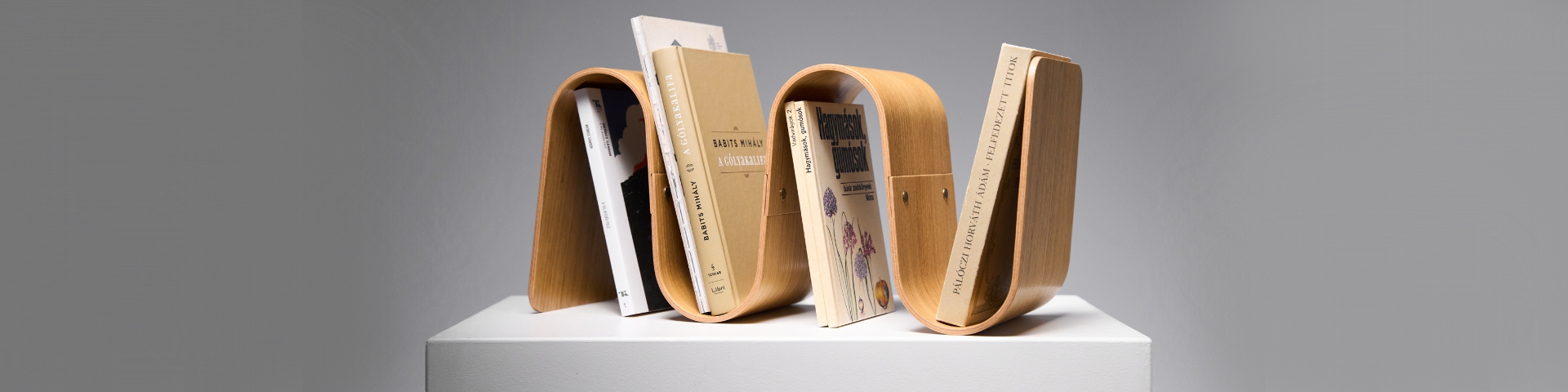 MEANDER bookend—modular curved plywood form inspired by river flows, blending display and support in a clean, sculptural aesthetic.