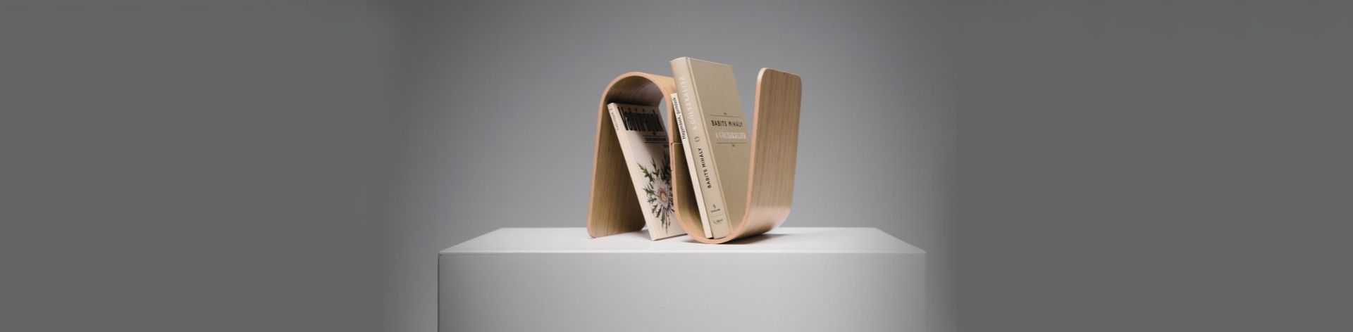 MEANDER bookend—modular curved plywood form inspired by river flows, blending display and support in a clean, sculptural aesthetic.